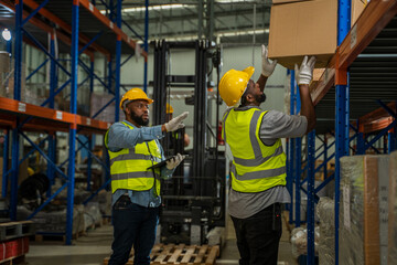 Warehouse worker checking and loading or unloading boxes in a large distribution warehouse.