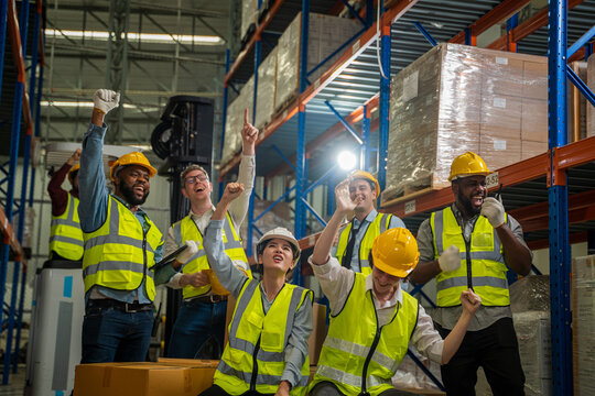 Warehouse workers are meeting together,Group of multicultural logistics employees working as a team in in a large distribution warehouse.
