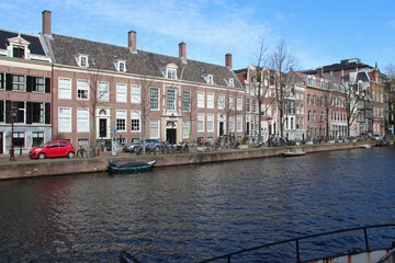 canal, river and old brick houses in amsterdam (the netherlands) 