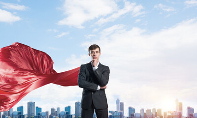 Fototapeta na wymiar Concept of power and sucess with businessman superhero in big city
