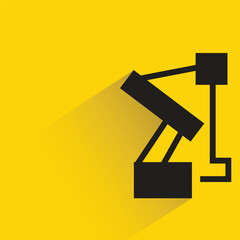 industrial robotic arm with shadow on yellow background