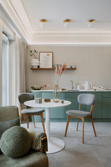 Interior design of dinning room interior with mock up poster frame, round table, chair, green armchair, round pillow, wallpaper, vase with dried flowers and personal accessories. Home decor. Template.
