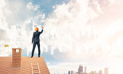 Man architect draw silhouette of modern city on blue sky. Mixed