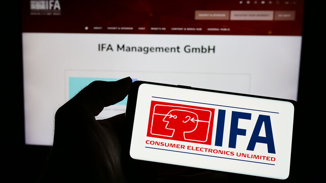 Stuttgart, Germany - 04-02-2023: Person holding mobile phone with logo of Internationale Funkausstellung Berlin (IFA) on screen in front of web page. Focus on phone display.