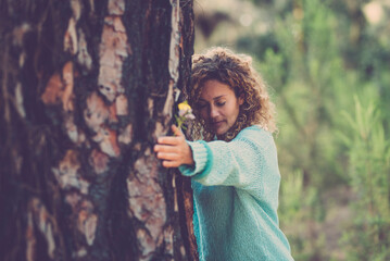 Nature love and environment. Sustainable lifestyle people. One woman bonding a big trunk tree in the forest woods. Concept of natural protection. Green woods background. Stop deforestation outdoors