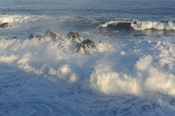Waves breaking and crushing on the rocks on the Atlantic Ocean on coastline and seashore of Madeira...