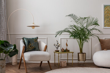 Warm composition of living room interior with boucle armchair, sofa, plant in gold pot, green...