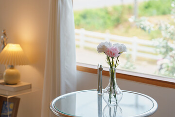 Fresh flowers in vase on modern clear table near window at bright living room interior Korea style.