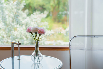 Fresh flowers in vase on modern clear table near window at bright living room interior Korea style.