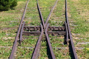 Abandoned railroad track where grass has grown through the lines