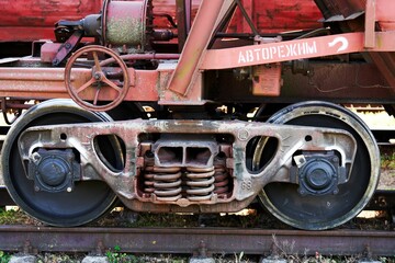 Old rail car truck tender that has auto mode in Russian on it,  on an abandoned railway