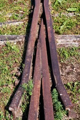 Fototapeta premium Vertical of an abandoned railroad track surrounded by grass
