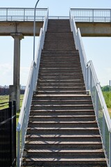 Vertical of outdoors stairs with metal stair case leading up captured against a clear sky