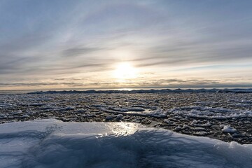 Fototapeta premium Beautiful view of an iceberg at sunrise in Tawas Point State Park, Michigan, USA during winter