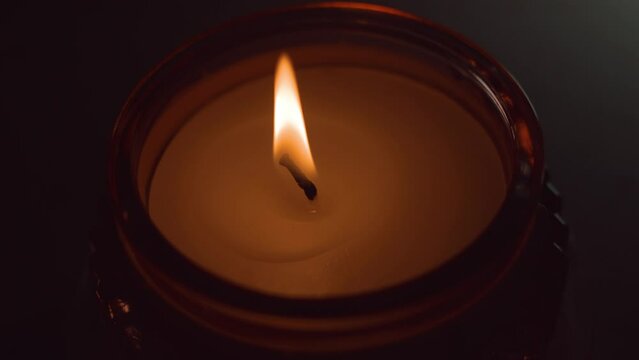Closeup of a burning candle in a small glass