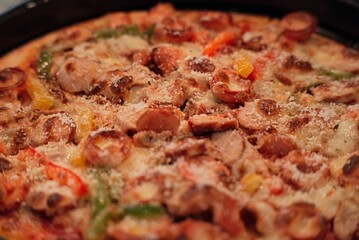 Closeup shot of a delicious deep dish pizza with meat and vegetable toppings