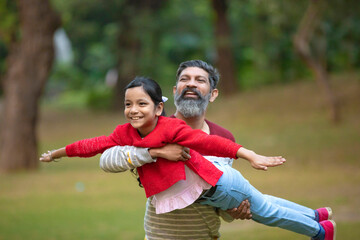 Indian man playing with his daughter at park