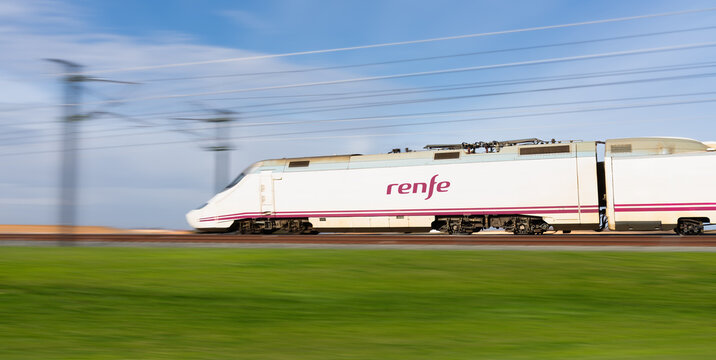 CUENCA, SPAIN - DECEMBER 20, 2021: High speed train Ave Renfe passing through the green fields in Cuenca province, Spain. Sustainable transport
