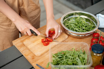 Cropped view of the young woman enjoying cooking and preparing salad