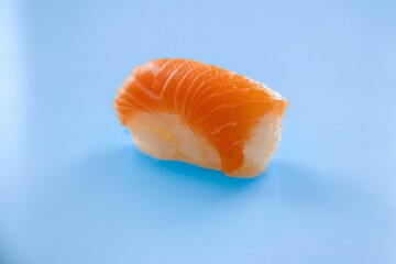 Salmon sushi roll isolated on a blue background