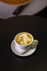 white cup with cappuccino with an intricate pattern.