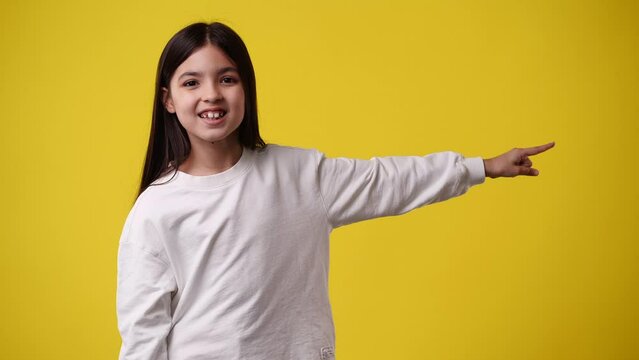 4k Video Of One Child Who Pointing His Finger To The Right And Smiling Over Yellow Background.