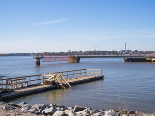 Piers at Kruunuvuori shore in Helsinki, a pier for winter swimmers on the left, Helsinki down town on the horizon, sunny day in April
