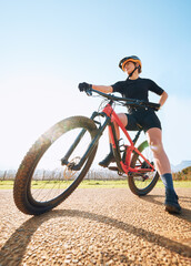Bicycle break, ride and woman on a bike from below for sports race on a gravel road. Fitness, exercise and athlete doing sport training in nature or countryside for cardio rest and healthy workout