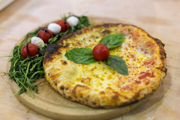 Italian pizza on a wooden plate. Freshly prepared pizza.