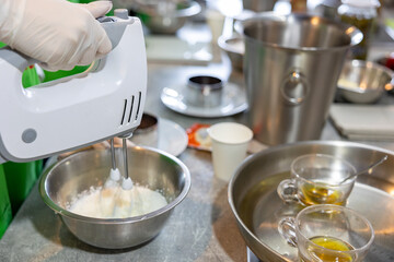 hands using electric mixer to make whipped cream