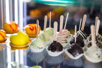 Cake pops. Mini cake on a stick. Сake on showcase.