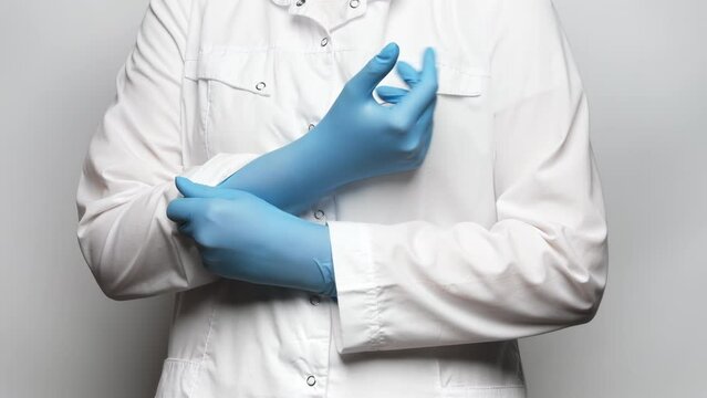 Close up shot of a doctor pulling up blue medical gloves. 4k, slow motion.