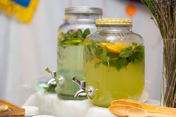 Lemonade dispenser close up with fruits: grapefruit, orange, lemon. Welcome zone of drinks with...