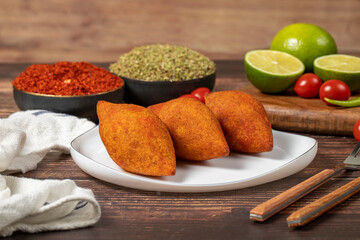 Turkish stuffed meatballs. Arabian and Turkish cuisine flavored icli kofte or kibbeh on a wood background.