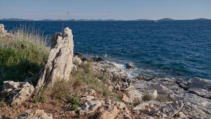 Fototapeta na wymiar Coast of Croatia with a pregnant stone in the foreground and blue sea