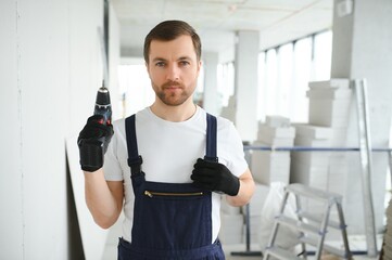 man drywall worker installing plasterboard sheet to wall.