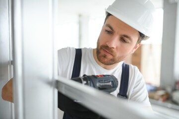 Naklejka na ściany i meble drywall worker works on building site in a house.