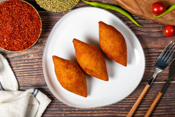 Turkish stuffed meatballs. Arabian and Turkish cuisine flavored icli kofte or kibbeh on a wood background. Top view