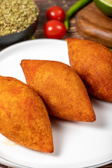 Turkish stuffed meatballs. Arabian and Turkish cuisine flavored icli kofte or kibbeh on a wood background. Close up