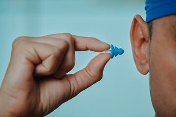 swimmer man about to put an earplug