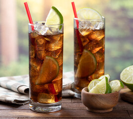 Rum and cola cocktail with lime slice