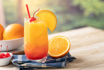 Tequila sunrise cocktail with orange slice and cherry - 592265639