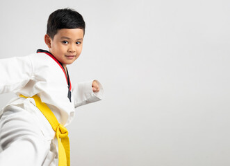 Portrait Asian boy kid karate martial arts. Taekwondo uniform with yellow belt. Asian school boy...