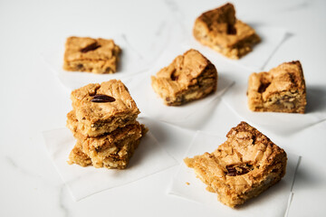 blondie cookies squares on white marble countertop background. White chocolate sweet and tasty, chewy cookie bars. 