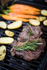 Beef steak with carrot and sweet potato on the grill. Top view