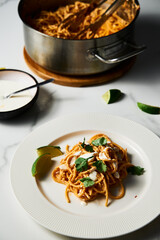 Plate with Mexican pasta. Pasta with tomato sauce with chilli puree, feta and cream cheese. Spaghetti macaroni boiled al dente and mixed with sauce