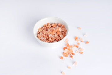 Fototapeta na wymiar Himalayan Pink Rock Salt. Mineral-rich salt from the Himalayan region. in ceramic jar on wite background.