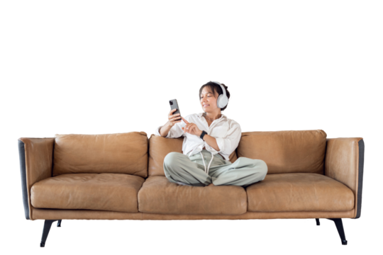 A woman is sitting on the couch using a phone audiobook resting listening to music with headphones, transparent background, isolated.