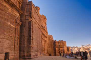 Petra w Jordanii. Ruiny starożytnego miasta w skale na tle błękitnego, bezchmurnego nieba. - obrazy, fototapety, plakaty