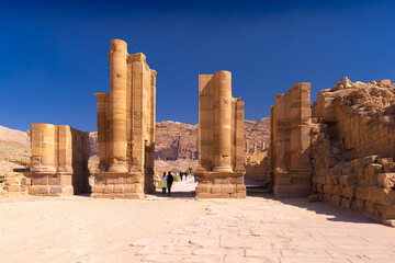 Petra w Jordanii. Ruiny kolumn starożytnego miasta na tle błękitnego, bezchmurnego nieba. - obrazy, fototapety, plakaty